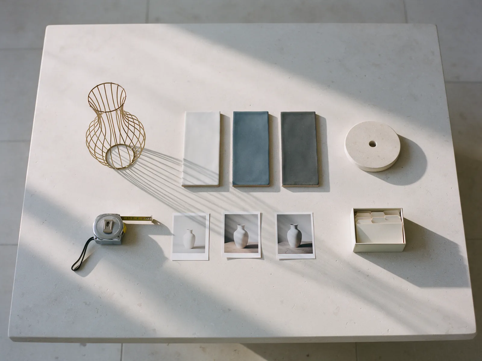 A wire vase sculpture, three glaze tiles, a turntable disc, a tape measure, three photographs of the same vase and an archive box.